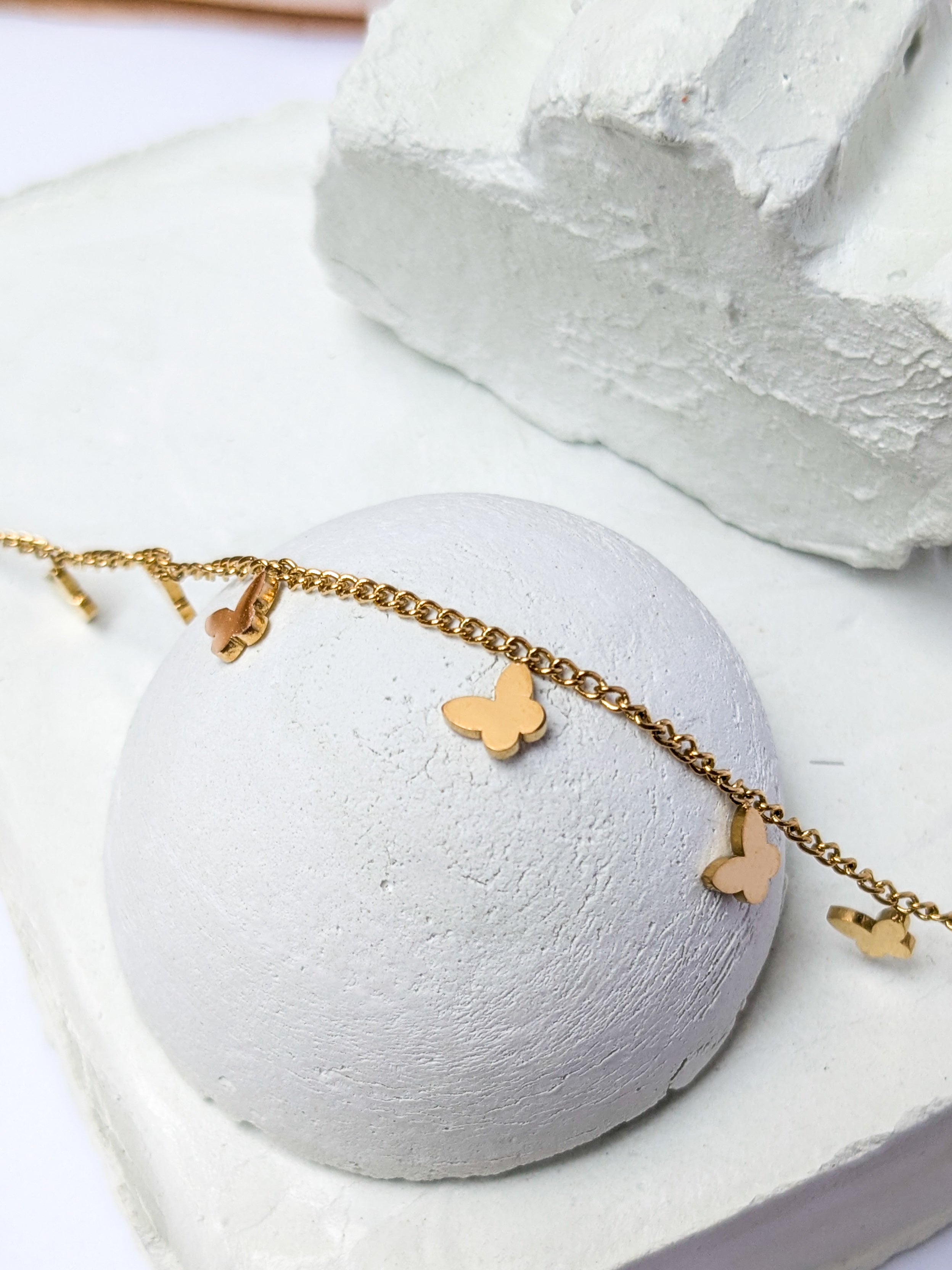 Gold charm bracelet with multiple small butterfly charms