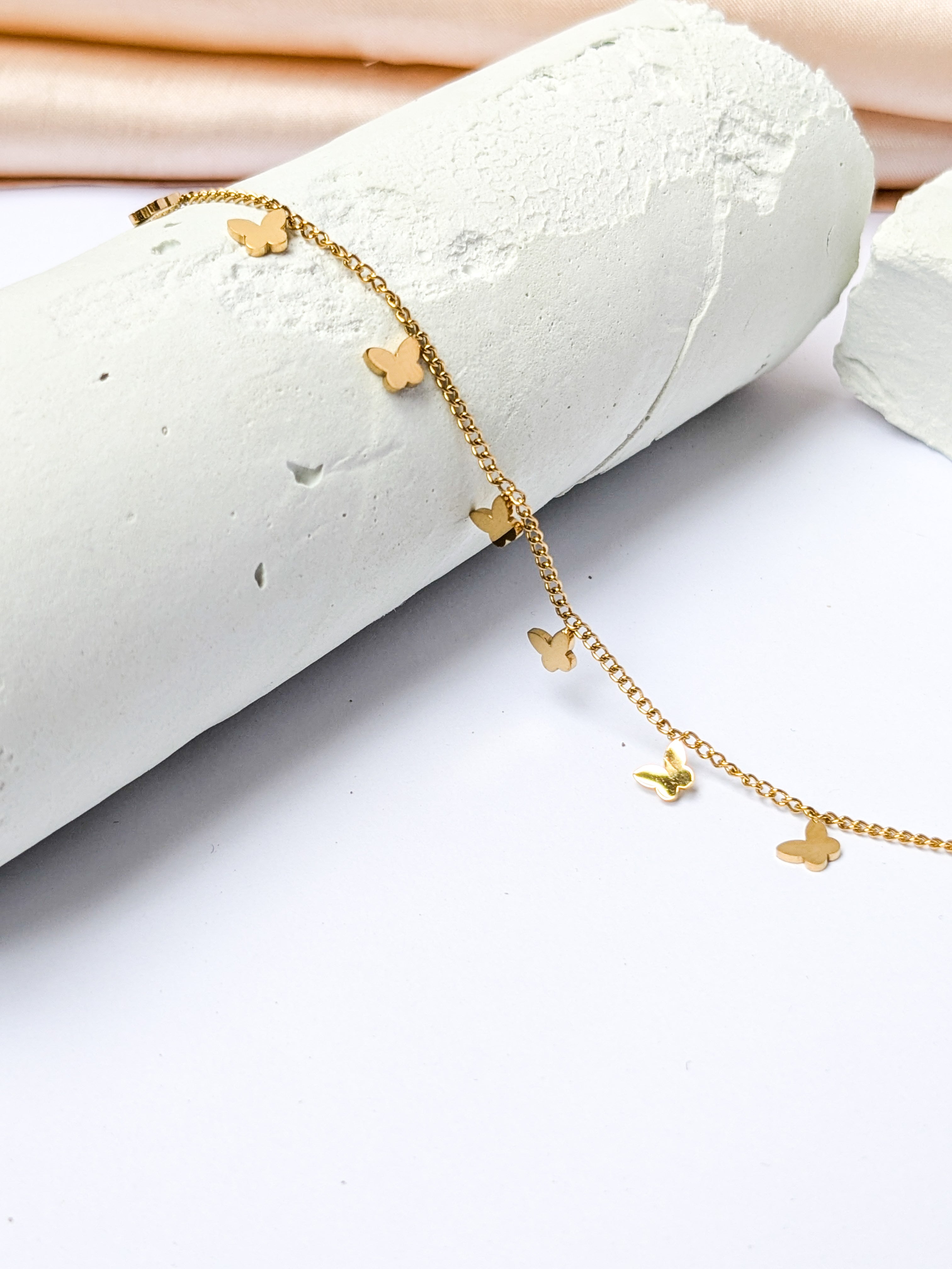 Gold charm bracelet with multiple small butterfly charms
