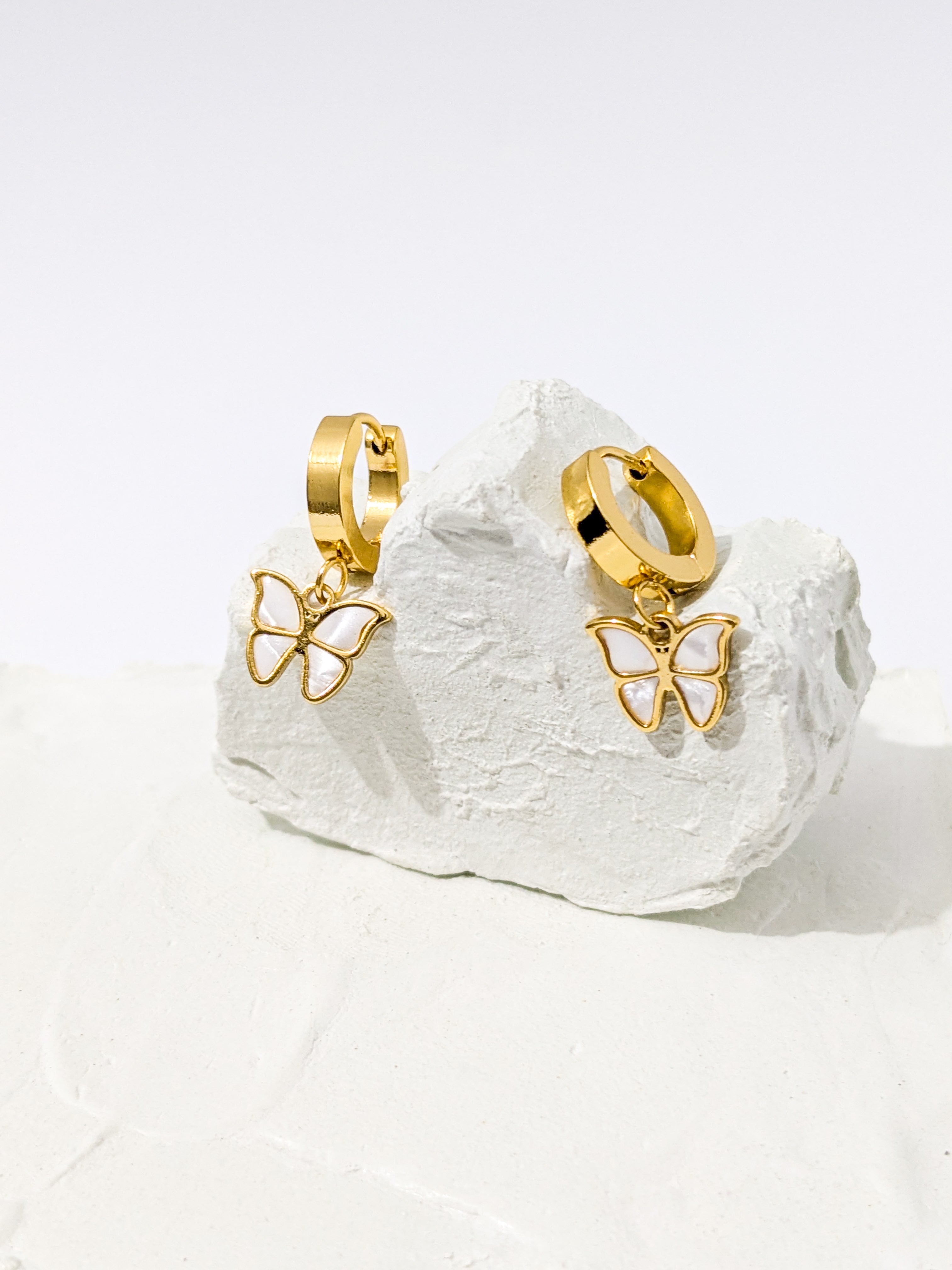 Gold hoop earrings with dangling butterfly charms