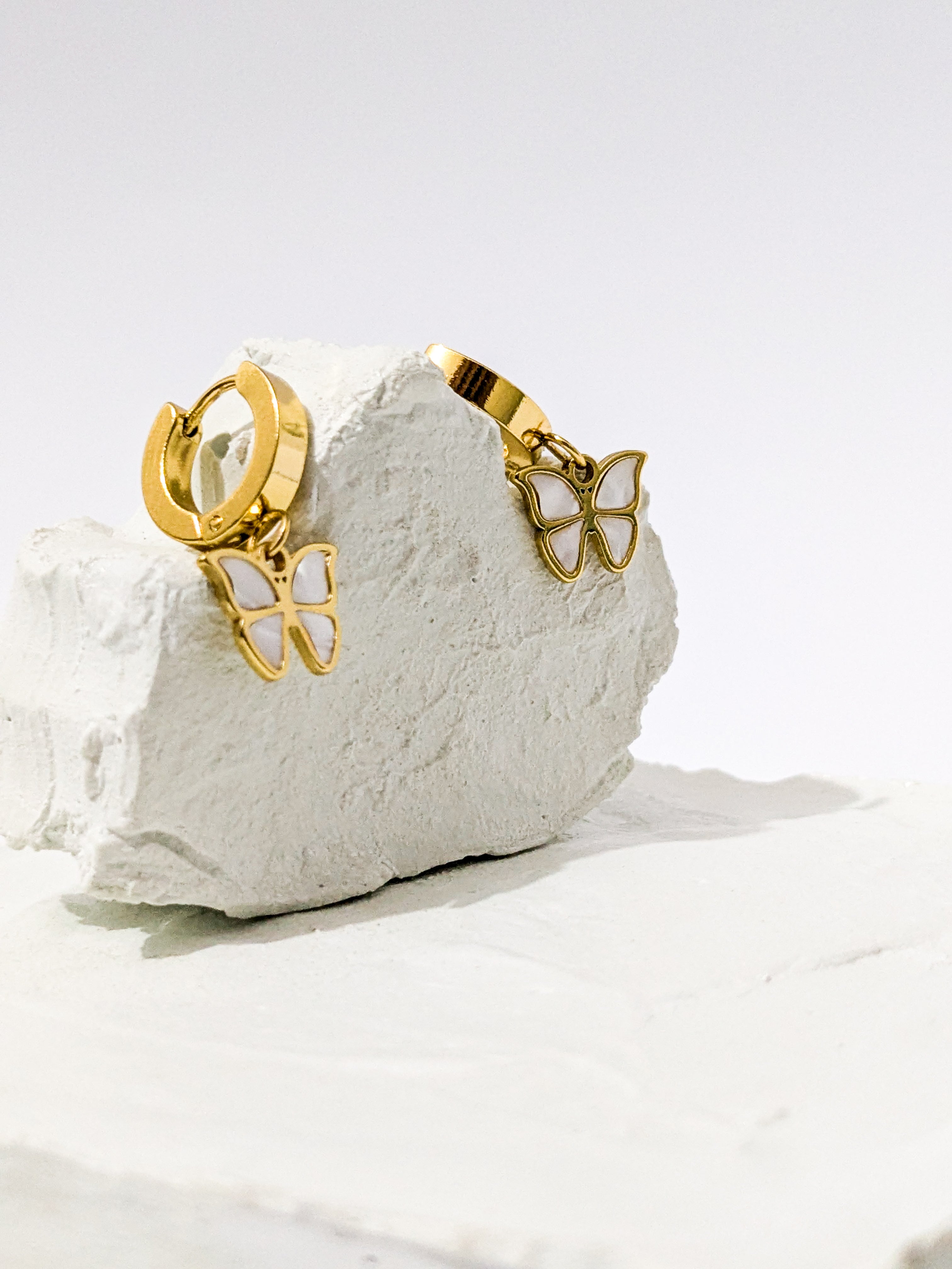 Gold hoop earrings with dangling butterfly charms