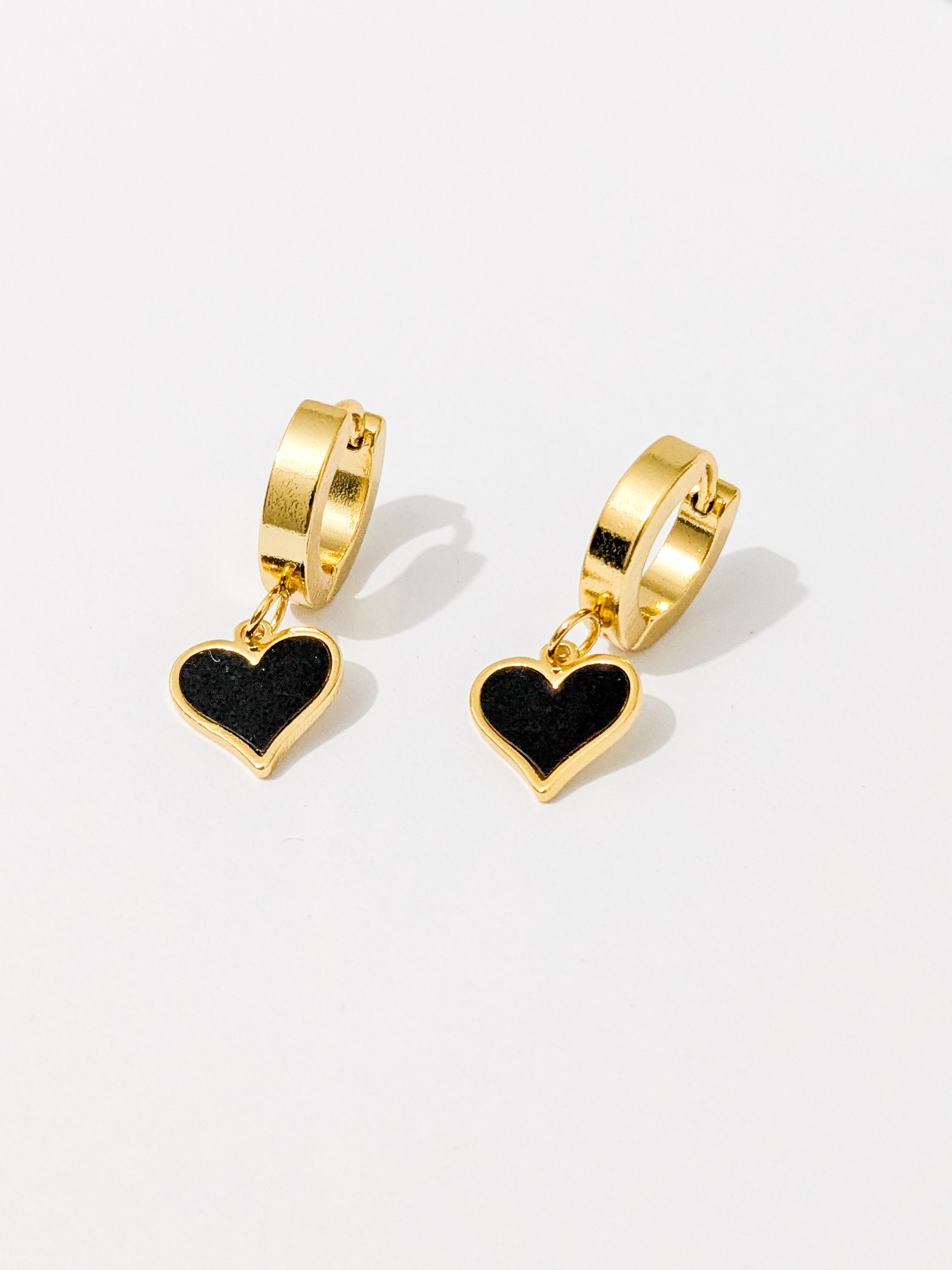 Gold hoop earrings with black heart-shaped dangles