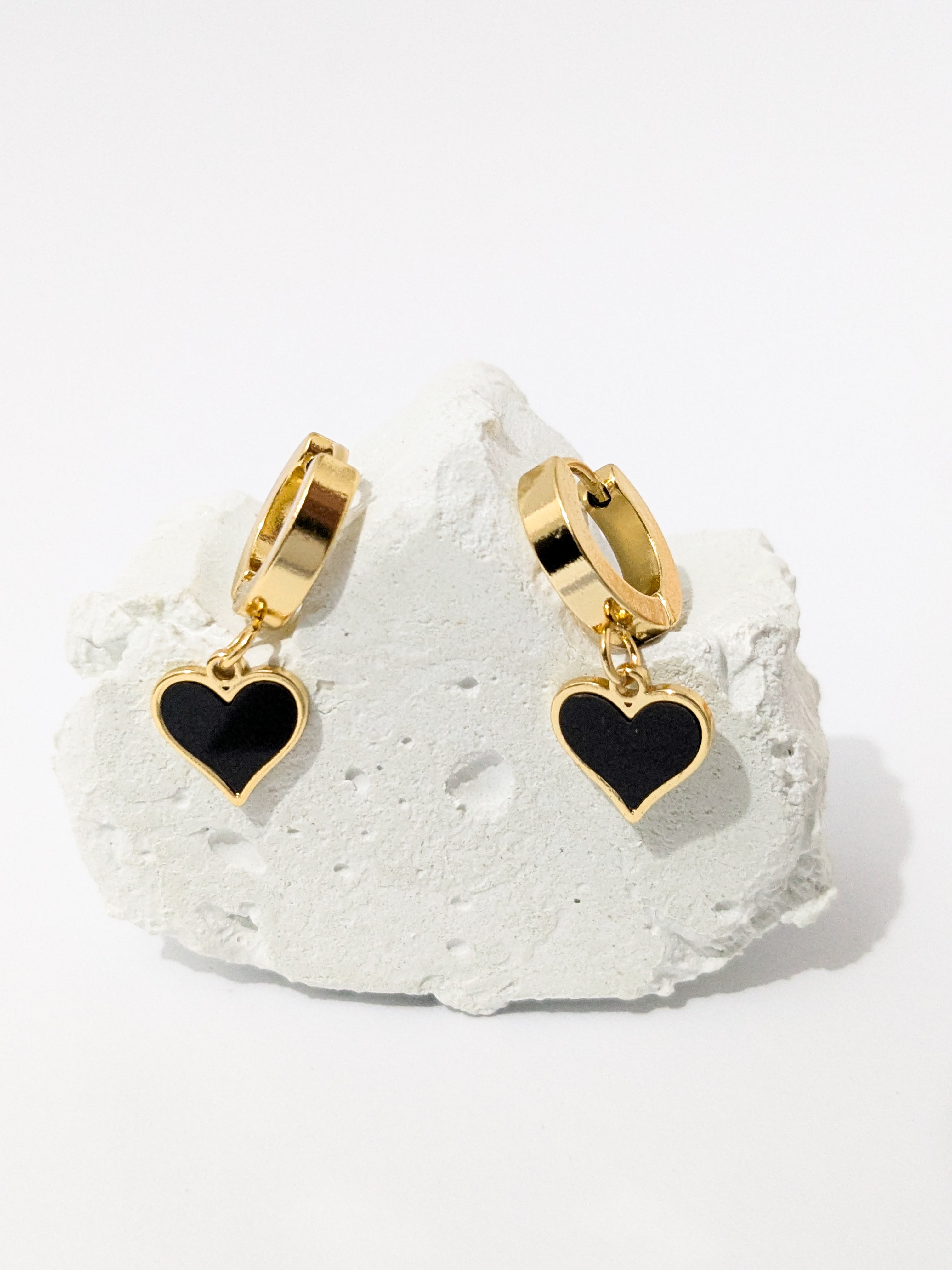 Gold hoop earrings with black heart-shaped dangles